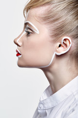 Side view of beautiful young woman. Female with an unusual creative makeup face paintin.