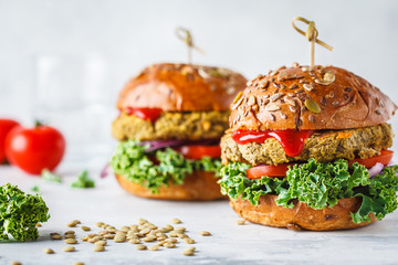 Vegan lentil burgers with kale and tomato sauce on a white background.