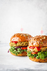 Vegan lentil burgers with kale and tomato sauce on a white background.