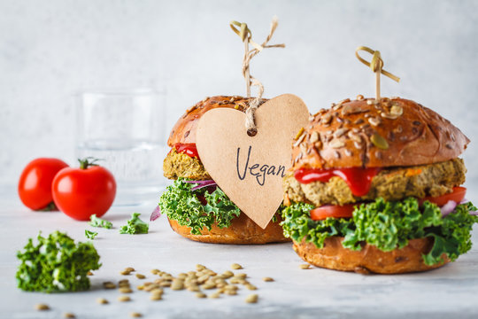 Vegan lentil burgers with kale and tomato sauce on a white background.