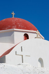 White Church with a Red Dome set against the beautiful blue skies of Mykonos, Greece