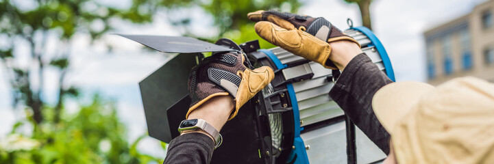 Grip team, light depurtment members prepare the lighting equipment before shooting BANNER, long...