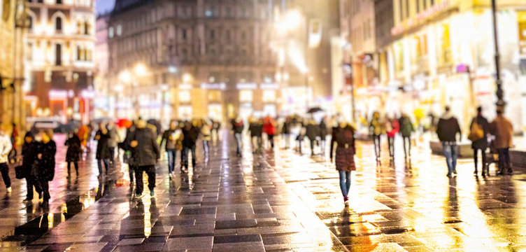 crowd of people walking on night streets in the city 