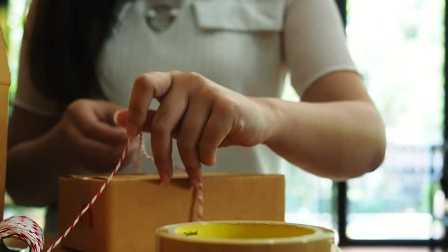 Business owner work at home wrapping parcel box, Alpha generation life style. Business woman entrepreneurial successful. Sales Online Parcel delivery. New generation life style of young entrepreneur.