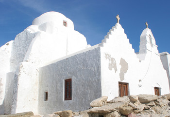 White church and cross set against the deep blue skies of Mykonos, Greece