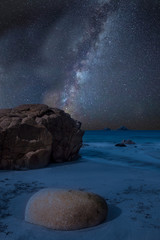 Vibrant Milky Way composite image over landscape of beautiful beach