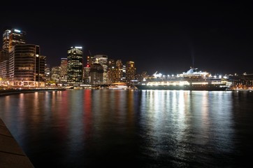 Wonderful Night view of colourful city and cruise ship near Harbor Bridge at Sydney, Australia. 
View at Sydney Harbour at night.
