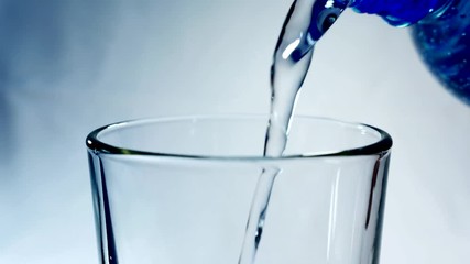 Mineral water from the bottle is poured into a glass. Pure living water.