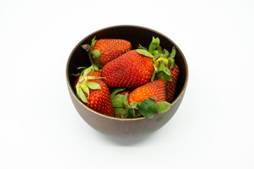 Strawberry in a wooden bowl isolated on white background.