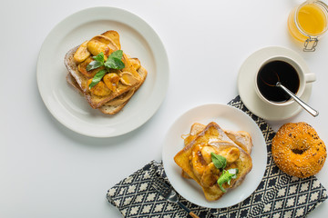 Toast with banana and mint, cup of coffee and bun with towel on white background top view with empty space
