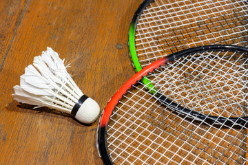 Badminton and Shuttlecock are placed on a wooden floor