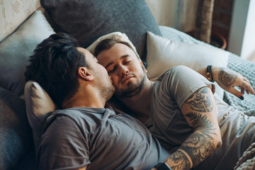Erotic gay caucasian couple bonding at bed, sleeping, tired after sleepless hot night, Same-sex...