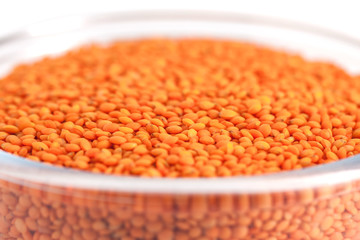 Yellow lentil in glass bowl isolated on white background