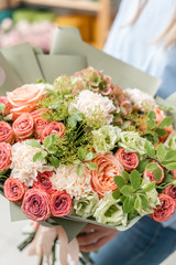 European floral shop. Bouquet of beautiful Mixed flowers in woman hand. Excellent garden flowers in the arrangement , the work of a professional florist.