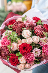 European floral shop. Bouquet of beautiful Mixed flowers in woman hand. Excellent garden flowers in the arrangement , the work of a professional florist.