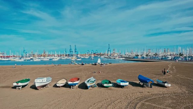 one of the city sandy beaches next to the harbor and marina with sailing yacht boats anchoring in the small bay and fishing dinghies