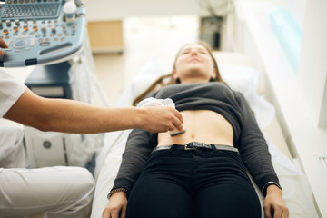gynecologist scanning the stomach of the client. close up photo. skanning before the surgery