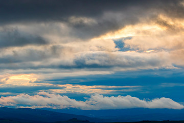 Cloudscape view over a rolling landscape at dusk