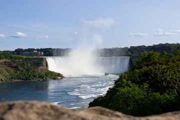 Fototapeta premium Wide view of the beautiful American side of the Niagara falls and a boat in front of it, from the Canadian side.