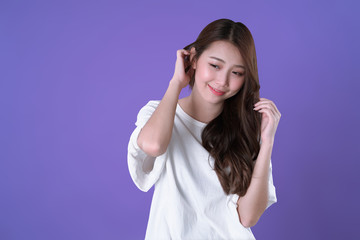 Fototapeta premium Asian woman long hair treatment, white t-shirt clothing, purple background