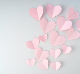 Pink paper hearts placed on white background.