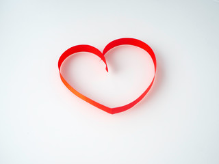 Red ribbon heart-shaped on a white background.