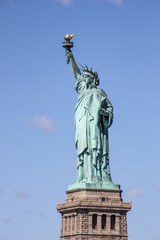 Fototapeta premium Statua Wolności w pobliżu Nowego Jorku i Manhattanu z łodzi z pięknym błękitnym niebem i chmurami w tle, Stany Zjednoczone