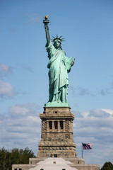 Obraz premium Statue of Liberty near New York city and Manhattan taken from a boat with a beautiful blue sky and some clouds in the background, United States