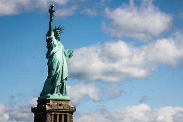 Obraz premium Statua Wolności w pobliżu Nowego Jorku i Manhattanu z łodzi z pięknym błękitnym niebem i chmurami w tle, Stany Zjednoczone