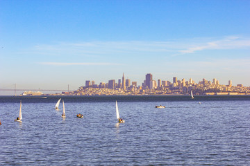 Skyscrapers and city of San Francisco with a view from the water - sea side at sunset.