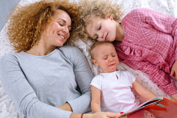 reading habit before the night. top view photo. naughty baby doesn't want to listen to fairy tailes