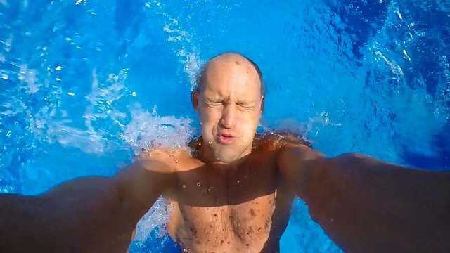 Young man jumps in the pool.