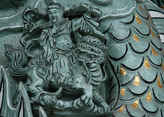 Man hero riding on a lion as stone carving cultural element in a temple in Taichung, Taiwan