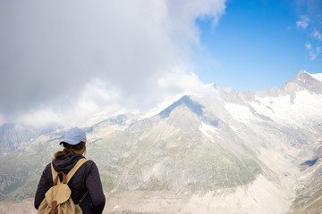 young modern woman hiker overlooking Swiss Alps at Aletsch glacier