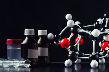 molecular formula and laboratory equipment on a dark background close up. Science organic chemistry...