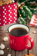 Red tea mug with cookies in Christmas decorations on a wooden table, selective focus
