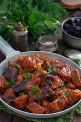 Stewed beef in tomato sauce with prunes, selective focus