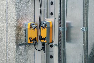 Two industrial orange damper actuators installed on the air handling unit