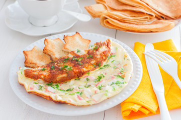 Omelet with crab sticks on a white plate with toast of white bread, horizontal