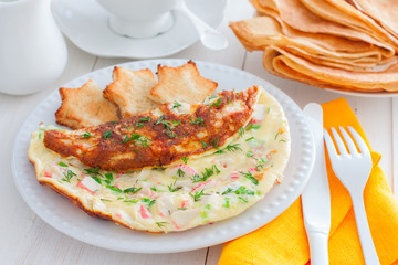 Omelet with crab sticks on a white plate with toast of white bread, horizontal