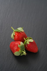 ripe strawberries on slate background