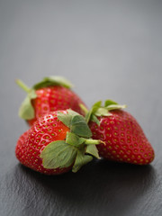 ripe strawberries on slate background