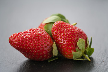 ripe strawberries on slate background