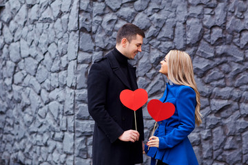 Couple with red heart in his hands on background.