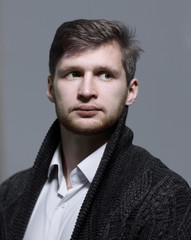 Obraz premium stylish young man in a knitted cardigan.isolated on grey background