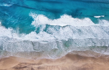 Fototapeta na wymiar Beach and waves from top view. Turquoise water background from top view. Summer seascape from air. Top view from drone. Travel concept and idea