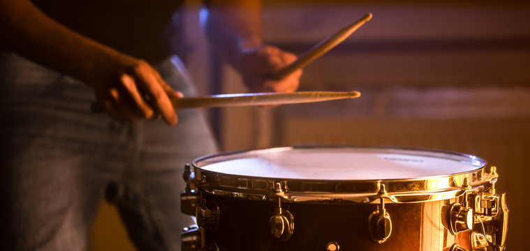 man playing the snare drum on a beautiful colored background