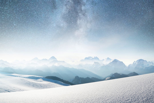 Fototapeta Góry i niebo z gwiazdami. Naturalny krajobraz w regionie gór w czasie zimy. Gwiaździste niebo i wysoki szczyt.