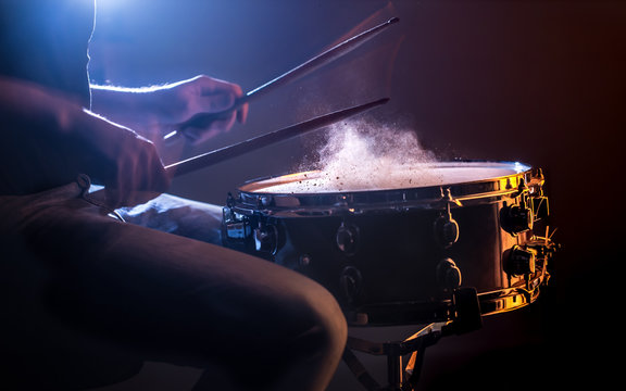 man playing the snare drum on a beautiful colored background