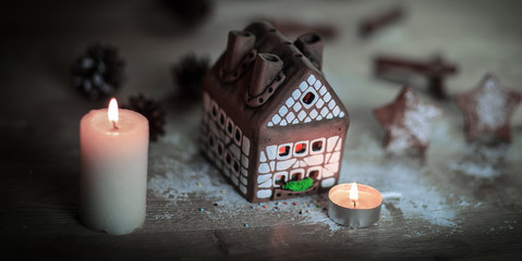 Fototapeta na wymiar gingerbread house candle on blurred background of the table.